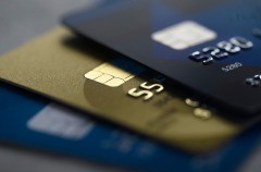 Image of three credit cards, two blue ones and one gold one.