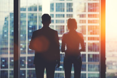 Image of a couple standing in front of a large window contemplating Chapter 11 Bankruptcy.