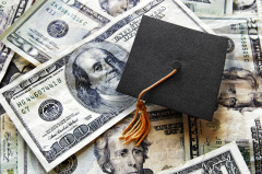Image of a graduation cap sitting on top of hundred dollar bills.